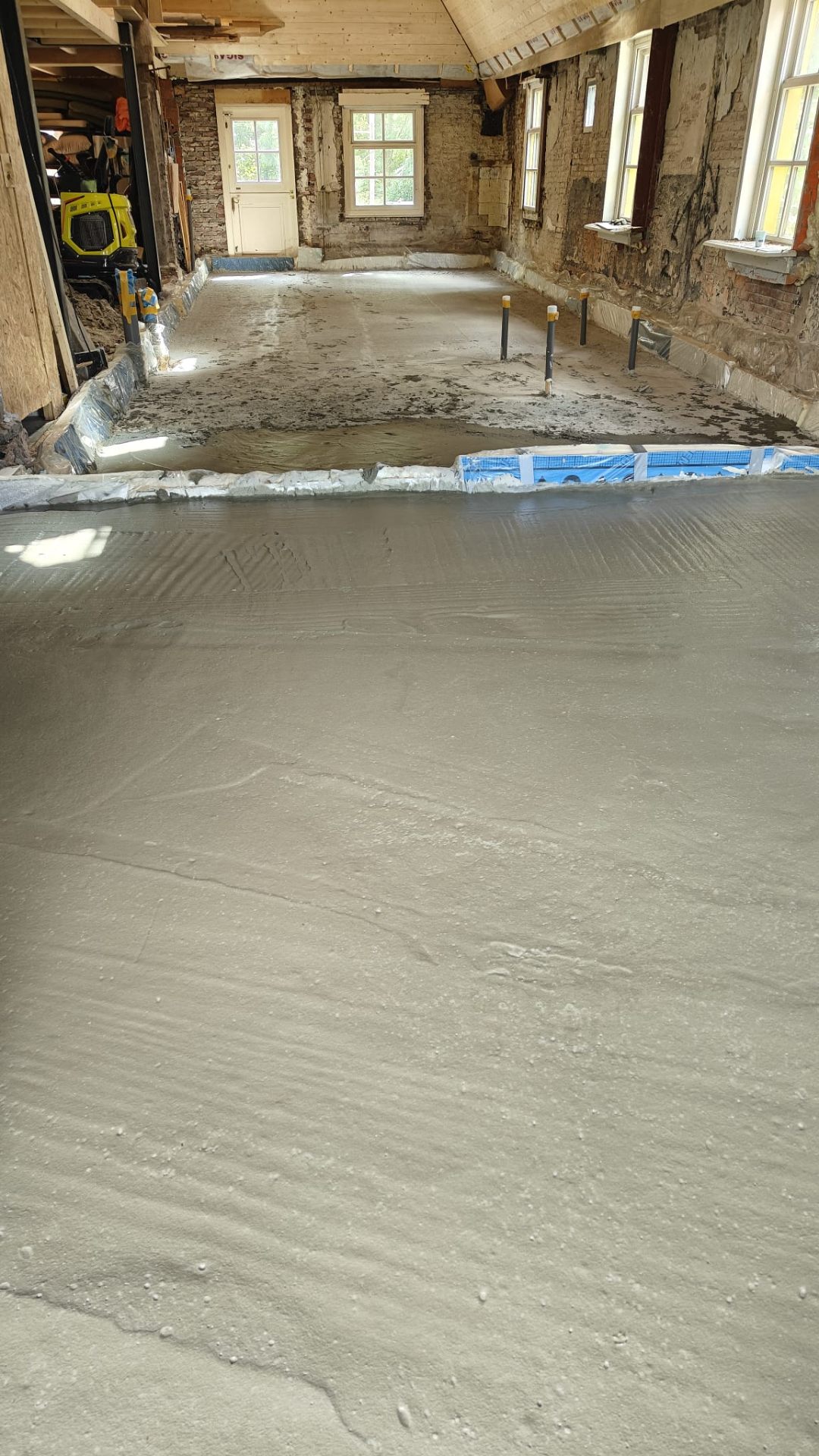 Renovatie van een monumentaal pand: verse Isopact cementgebonden isolatievloer gestort tussen originele bakstenen muren